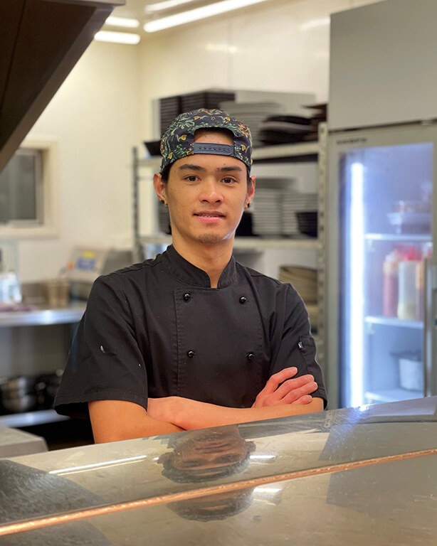 The Fat Duck Te Anau's Junior Sous Chef, Jovin Dorin, standing with arms crosses in the kitchen.
