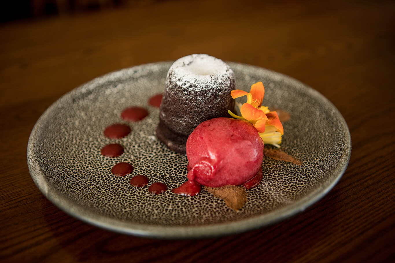 A plate of chocolate dessert served alongside a berry sorbet.