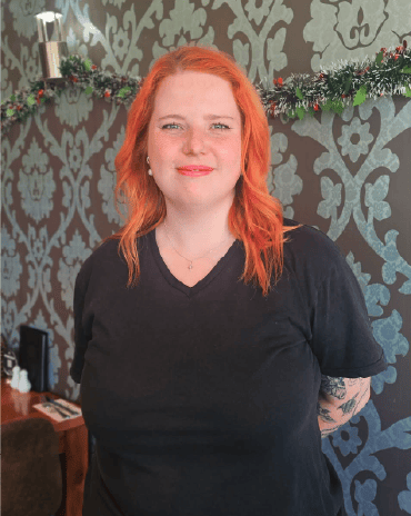 Niamh standing inside The Fat Duck Te Anau restaurant dining area.