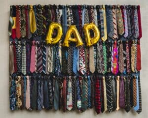 A wall of ties with a 'DAD' balloon tied across it.